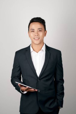 A handsome young businessman using a digital tablet on white background.