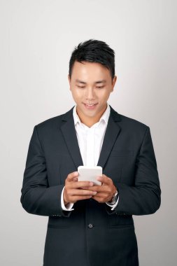 Beyaz arka planda cep telefonu kullanan yakışıklı bir iş adamı.