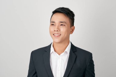 Beyaz arka planda gülümseyen Asyalı genç adam.