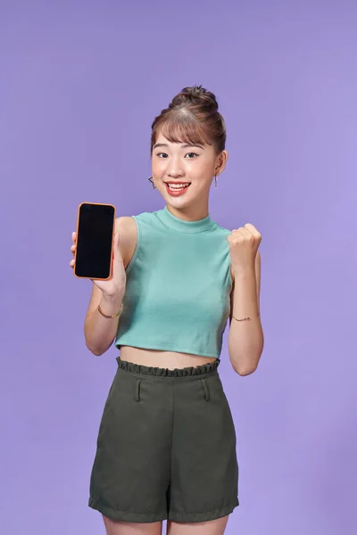 Молода Азіатка Яка Тримає Телефон Радісним Обличчям Фіолетовому Фоні — стокове фото
