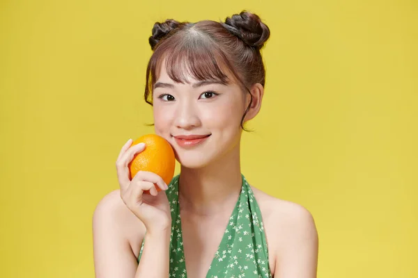 Счастливая Молодая Женщина Держит Оранжевый Желтом Фоне — стоковое фото