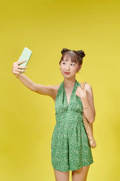 年轻而快乐的女人穿着夏装的形象让她在智能手机上显得很自恋 — 图库照片