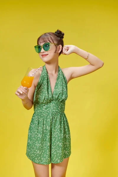 幸せな笑顔アジアの若いです女性飲む新鮮なオレンジジュースでガラス — ストック写真