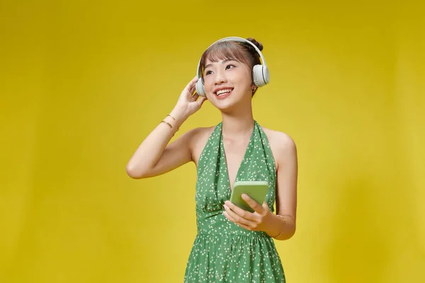 Jovem Mulher Ouvindo Música Segurando Telefone Isolado Cor Amarela Fundo — Fotografia de Stock