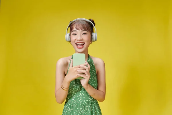 Молода Жінка Слухає Музику Тримає Телефон Ізольований Жовтий Колір Фону — стокове фото