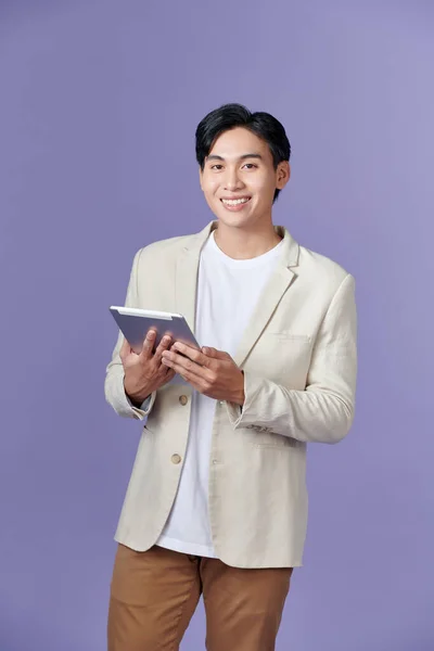 Счастливый Привлекательный Молодой Человек Стоит Использовать Планшет Фиолетовом Фоне — стоковое фото