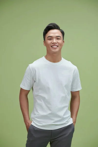 薄緑の背景に孤立した笑顔の若いアジアの男のハンサムな肖像画 — ストック写真