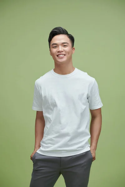 Açık Yeşil Arka Planda Sıradan Giyinmiş Gülümseyen Asyalı Genç Bir — Stok fotoğraf