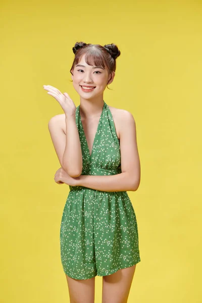 幸福アジアの女性は手のジェスチャーで立って緑のジャンプスーツで笑顔表情 — ストック写真