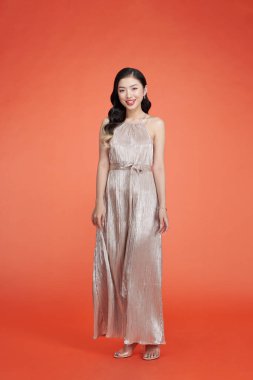 Moda elbisesi içinde gülümseyen güzel bir kadının portresi.