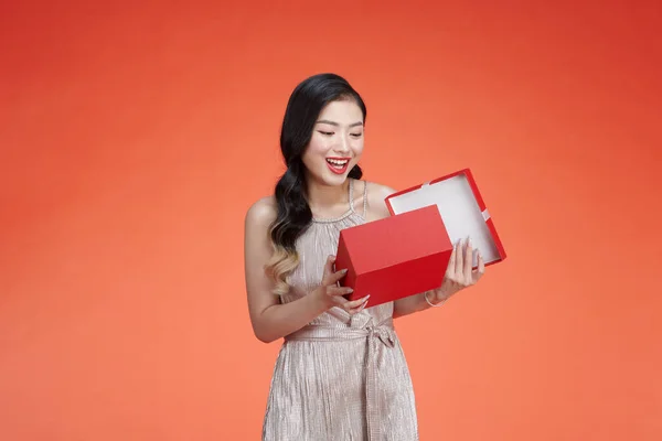 アジアの若いです女の子でドレス保持赤ギフトボックスとともに陽気な表現上の背景 — ストック写真
