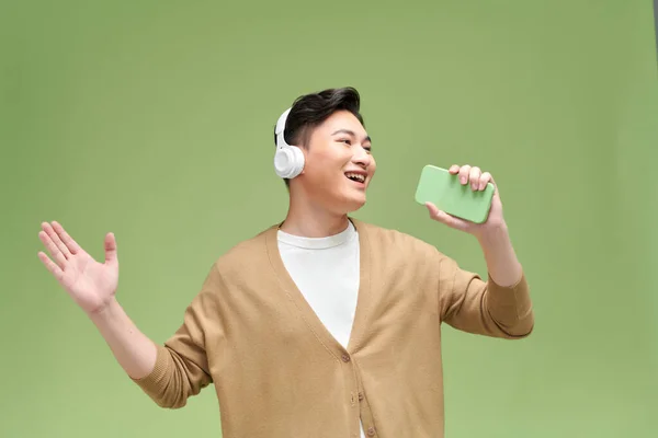 Emocionální Mladý Muž Sluchátkách Poslouchající Hudbu Zpívající Píseň Používající Smartphone — Stock fotografie