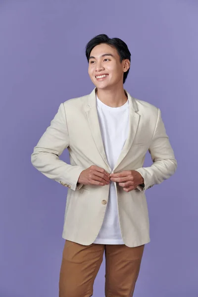 穿着米黄色西服的年轻亚洲商人面带微笑 背景是紫色的 — 图库照片