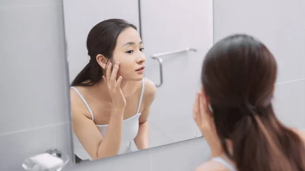Una Mujer Joven Mirando Espejo Examina Piel Tocando Cara — Foto de Stock