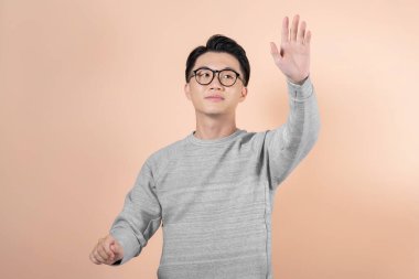 Genç işadamı bej arka planda sanal ekran kullanıyor