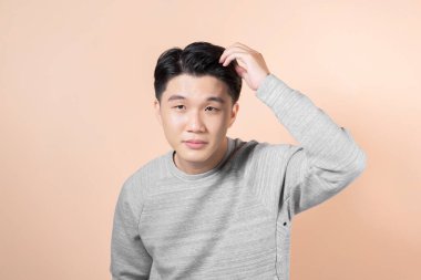 Sağlıklı adamın saçlarını parmaklarıyla taradığı bir fotoğraf.