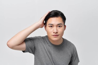 Yakışıklı erkek model saçına dokunuyor.