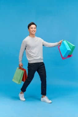 Asya genç adam alışveriş torbaları, tam uzunlukta portre izole holding.