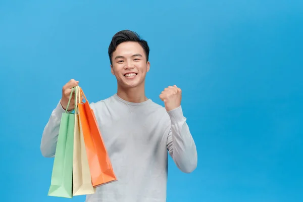 Junge Asiatische Mann Super Glücklich Mit Einkaufstaschen Isoliert Auf Blauem — Stockfoto
