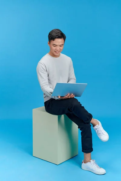 Человек Сидящий Белом Кубе Ноутбуком — стоковое фото