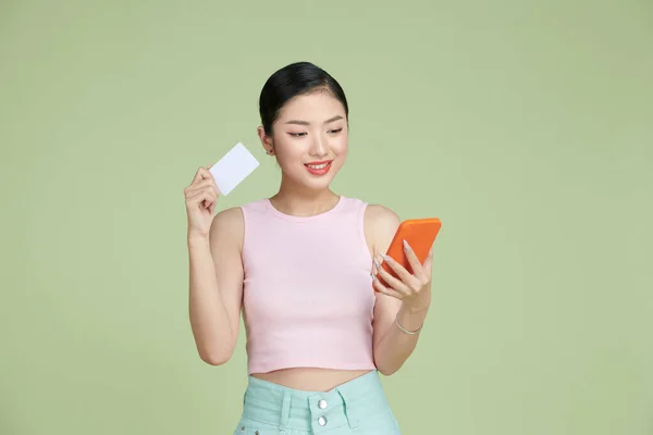 Молодая Азиатка Изолирована Зеленом Фоне Покупая Мобильного Помощью Кредитной Карты — стоковое фото