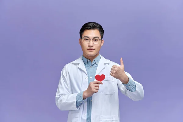 Elinde Kağıt Kalp Tutan Genç Bir Doktor Parmaklarını Mor Arka — Stok fotoğraf
