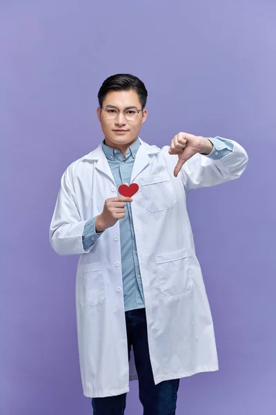 心脏病医生持有红心的妇女 对拇指下垂表示不喜欢的负面信号 排斥观念 — 图库照片