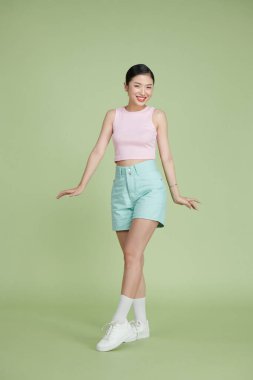 Harika Asyalı kız pozu veren uzun bir portre. 