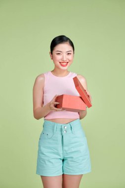 Emotional brunette young woman opens gift box, having overjoyed ecstatic facial expression