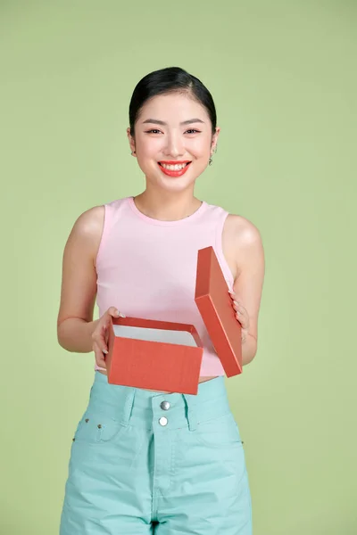 Χαρούμενη Νεαρή Γυναίκα Ανοίγοντας Παρόν Κουτί Απομονώνονται Ένα Πράσινο Φόντο — Φωτογραφία Αρχείου
