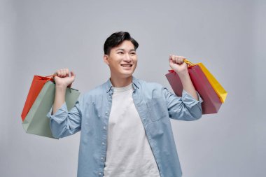 Asya genç adam alışveriş torbaları, tam uzunlukta portre izole holding.