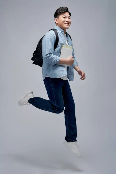 Full Length Smiling Young Asian Man Holding Books Jumping — Stock Photo, Image