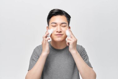 Genç adam yüzünü yıkıyor.