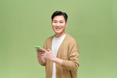 Mutlu Asyalı genç adam aramalar için akıllı cep telefonu kullanıyor.