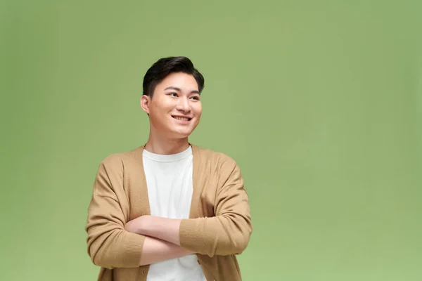 Glimlachende Jonge Aziatische Man Met Gekruiste Armen Groene Achtergrond — Stockfoto