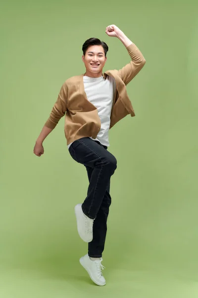快乐精力充沛的年轻亚洲男人跳跃着紧握着拳头 孤身一人 — 图库照片