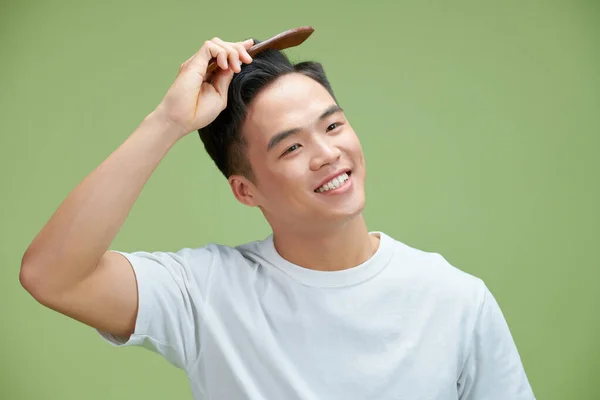 People Concept Smiling Young Man Brushing Hair Comb Green Background — Stock Photo, Image