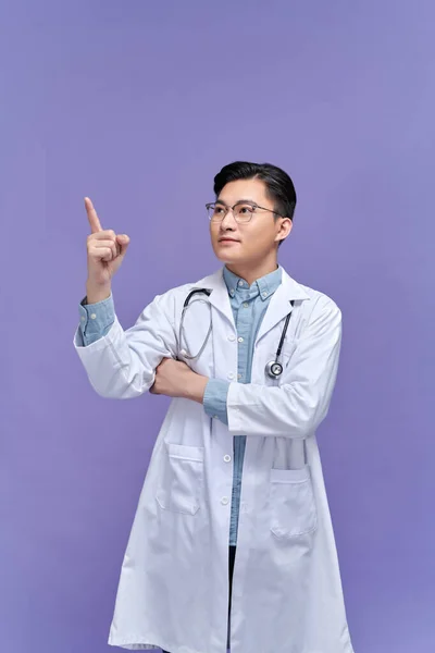 Junger Gutaussehender Arzt Lächelt Fröhlich Und Zeigt Mit Dem Zeigefinger — Stockfoto