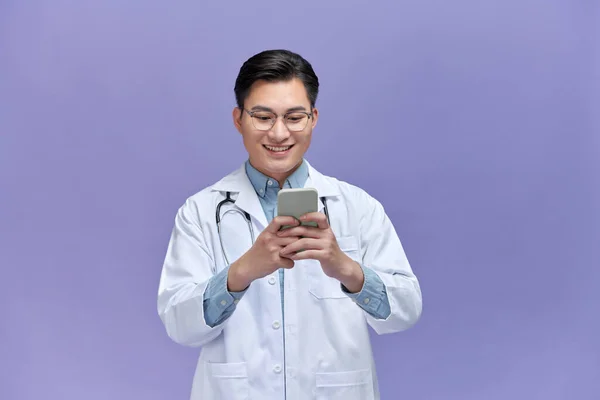 Ritratto Medico Maschio Utilizzando Telefono Cellulare Sorridente Isolato Sfondo Viola — Foto Stock