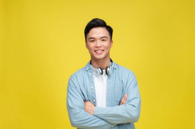 Boynunda kulaklıkla gülümseyen genç adam. 