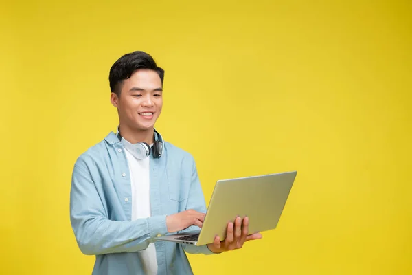 Sorrindo Jovem Usando Laptop Olhando Para Câmera Sobre Fundo Amarelo — Fotografia de Stock