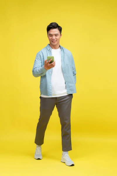 Gülümseyen Genç Bir Adamın Portresi Cep Telefonu Kullanıyor Sarı Arka — Stok fotoğraf
