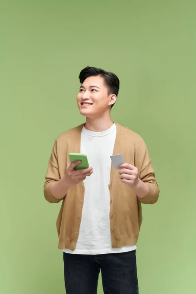 Glimlachende Man Met Creditcard Mobiele Telefoon Terwijl Hij Tegen Een — Stockfoto