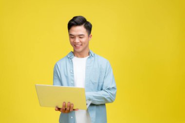 portrait of young businessman standing using laptop