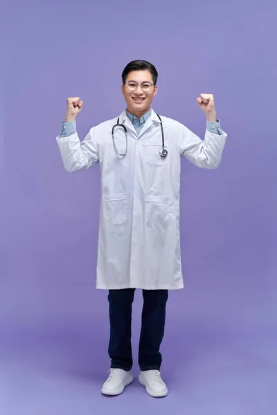 Beyaz Üniformalı Yumrukları Havada Gülümseyen Genç Bir Doktor — Stok fotoğraf