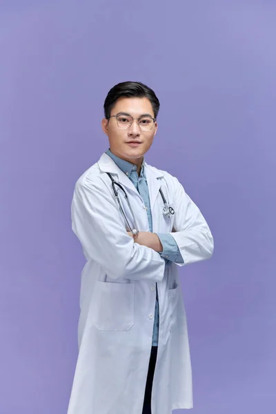 医生交叉着双臂摆出一副医生的架势 医护人员背景是紫色的 — 图库照片