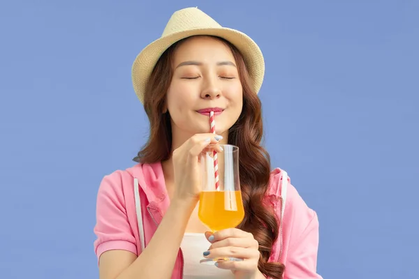 年轻美丽的女人戴着夏帽在度假 喝橙汁 — 图库照片