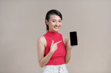 Asyalı güzel bir kız cep telefonundan mesaj atıyor ya da kablosuz bağlantı ile akıllı telefon kullanıyor.