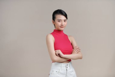 Stüdyoda kolları çapraz duran gri kazaklı mutlu kızıl kadın.