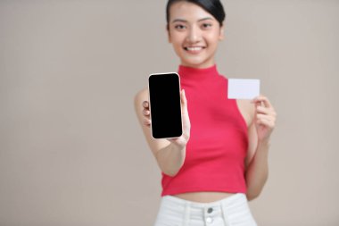 Asyalı Kadın akıllı telefon kullanıyor ve online işlemler yapıyor.